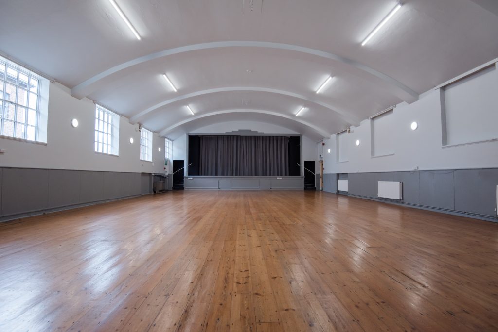 Large Hall with wooden floors and curved ceiling.